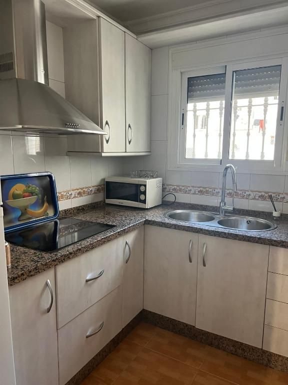 Cocina con vitrocerámica y microondas