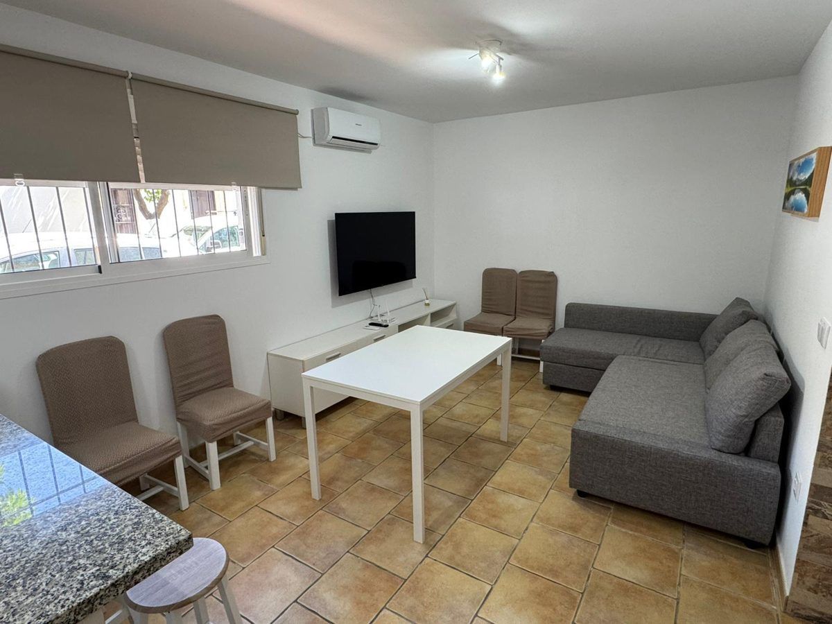 Salón con sofá chaise longue, mesa y smart TV